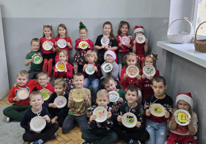 Przedszkolaki chwalą się przygotowanymi własnoręcznie odznakami i medalami