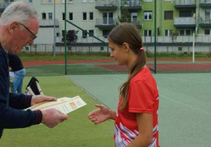 Dziewczynka odbiera dyplom dla drużyny