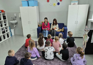 Ogólnopolski Dzień Głośnego Czytania - uczennice czytają książkę przedszkolakom