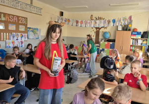 Wolontariusze zbierają pieniążki do puszki w klasach