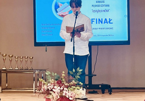 Uczeń na scenie czyta książkę