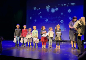 Dzieci na scenie odbierają nagrody