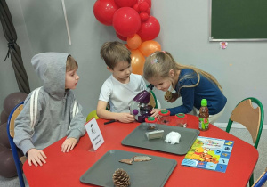 Dzieci oglądają przez mikroskop przygotowane preparaty