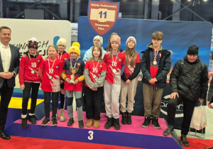 Szkolna drużyna na wspólnym zdjęciu na podium