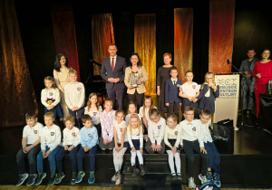 Grupa teatralna uczniów z klasy 1b na wspólnym zdjęciu po odebraniu nagrody