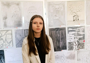 Zdjęcie laureatki konkursu przy wystawie prac konkursowych