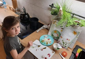 Dziewczynka przygotowująca dekorację wielkanocną na talerzu