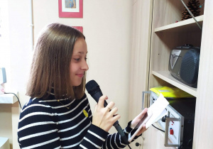Przewodnicząca szkoły czyta przez radiowęzeł ciekawostki dotyczące uśmiechu