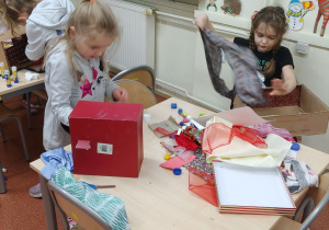 Dzieci projektują pomieszczenie domu z tekturowych pudełek