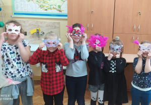 Wychowankowie świetlicy szkolnej prezentują wykonane przez siebie maski