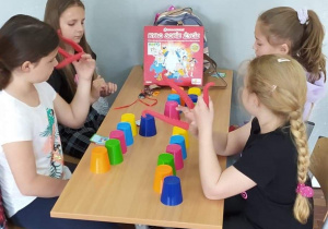 Uczniowie klasy 3b w sali grają przy stolikach w gry planszowe
