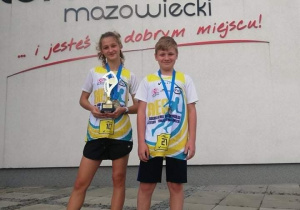 Antonina Krawczyk i Antoni Kubacki z pucharem i medalem za udział stoją na tle areny