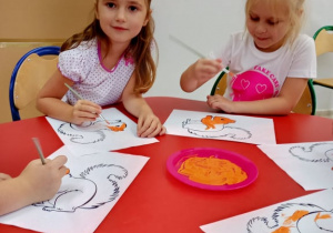 Dziewczynki malują farbami wiewiórkę