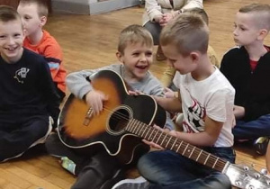 Chłopcy grają na gitarze
