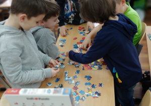 Dzieci wspólnie układają puzzle