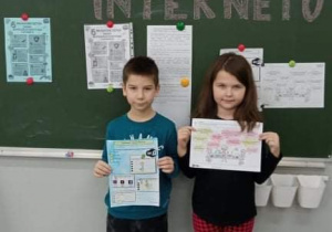 Uczniowie klasy 1b stoją przy tablicy z napisem DZIEŃ BEZPIECZNEGO INTERNETU