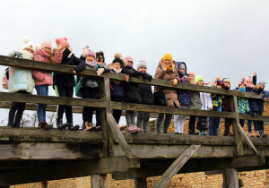 Grupa uczniów na moście wiodącym do zamku.