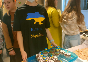 Uczennica w podkoszulce z grafiką mapy Ukrainy i z napisem w języku ukraińskim- WOLNA UKRAINA