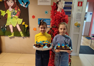 Dziewczynki prezentują babeczki z flagami Ukrainy