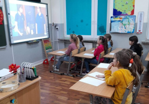 Uczniowie klasy 2a w trakcie lekcji patrzą na tablicę multimedialną biorąc udział w warsztatach