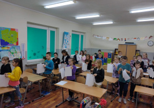 Dzieci z klasy 3c wykonują doświadczenie z kartką papieru