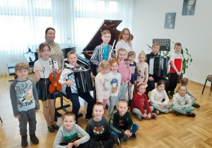 Grupa 0b na wspólnym zdjęciu przy fortepianie z uczniami szkoły muzycznej