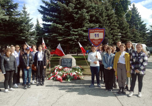 Uczniowie pod obeliskiem poświęconym "Rodakom zamordowanym i zaginionym w Rosji Carskiej i Sowieckiej ".