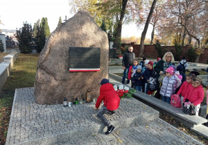 Pierwszoklasiści zapalają znicz przy tablicy poświęconej pamięci Henryka Dobrzańskiego -Hubala