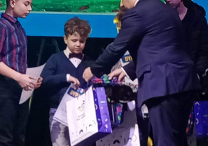 Chłopiec odbiera nagrodę z rąk prezydenta miasta P. Marcina Witko