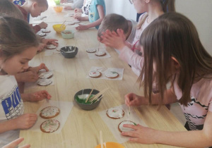 Dzieci ozdabiają ciastka lukrem