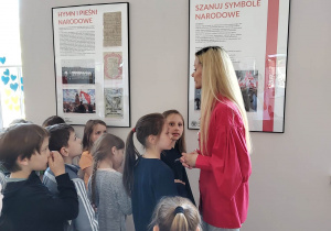 Uczniowie zwiedzają wystawę na temat polskich symboli narodowych