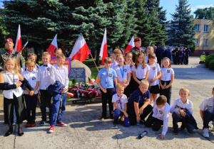 Uczniowie przy pomniku Sybiraków przed kościołem przy ul. Słowackiego