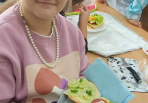 Dziewczynka prezentuje wykonana przez siebie zdrową kanapkę
