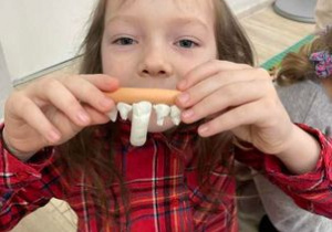 Dziewczynka z ulepionymi z plasteliny zębami