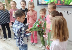 Chłopiec wręcza dziewczynkom tulipany