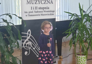 Dziewczynka z mikrofonem podczas występu w Państwowej Szkole Muzycznej