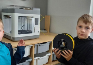 Uczniowie wymieniają filament w drukarce 3D