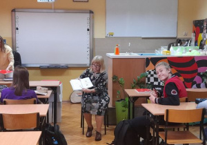 Pani Danuta Iwanowska kierownik biblioteki pedagogicznej czyta uczniom książkę