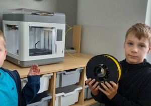 Uczniowie wymieniają filament w drukarce 3D